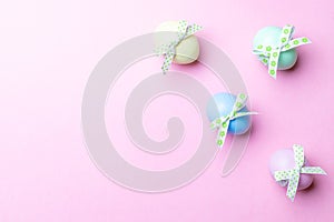 Easter message. Colourful egg with tape ribbon on pastel pink background in Happy Easter decoration. Foil minimalist egg design,