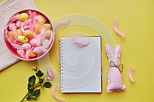 Easter mock up notepad. Pink bowl with colorful eggs, pink feathers, pink rose and handmade cute bunny. Happy Easter