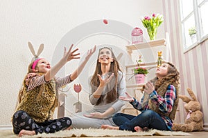 Easter - Mother and two daughters chocolate eggs thrown