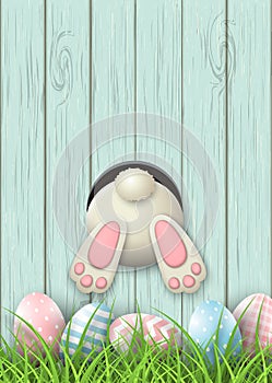 Easter motive, bunny bottom and easter eggs in fresh grass on blue wooden background, illustration photo