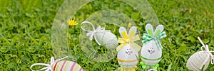 Easter object. colored hand painted easter eggs with bunny ears, symbols of the holiday. composition on green grass
