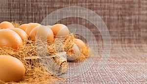 Easter, organic healthy food concept with copy space. Brown eggs on cross section of tree trunk with wicker background.