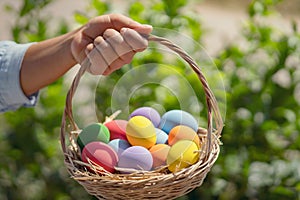 easter painted eggs in basket hand holding on green background