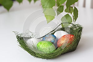 Easter - pascha, blue, green, red, white egg in grassy basket