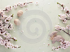 Easter photo. Blooming branch, handmade hare and eggs on a light background