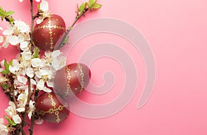 Easter pink background with Easter eggs and spring flowers. Top view with copy space