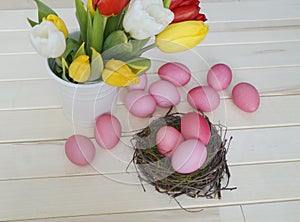 Easter. Pink easter eggs and tulips lie on a wooden background. Flat lay.