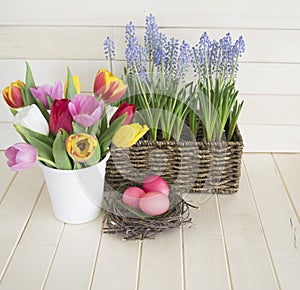 Easter. Pink easter eggs and tulips lie on a wooden background. Flat lay.