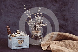 Easter quail egg composition in a wooden box with a chocolate Easter bunny willow branches in a vase