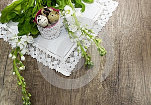 Easter quail eggs on a linen napkin, beautiful blossoms