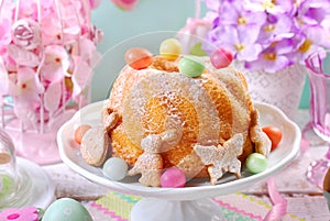 Easter ring cake with candy eggs and cookies on spring table