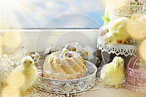 Easter ring cake and seasonal decors on windowsill in sunny day photo