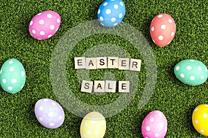 Easter sale banner with colorful eggs and sale text on a green grass background.