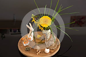 Easter scene with yellow and orange, spring flowers and decorative easter bunnies, angel and chicken