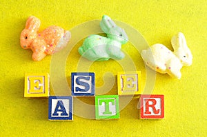 Easter spelled with alphabet blocks and a colorful bunnies