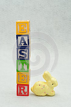 Easter spelled with alphabet blocks and a yellow bunny