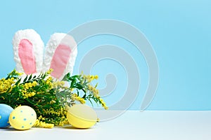 Easter spring composition. Rabbit ears flowering branch and eggs on the table