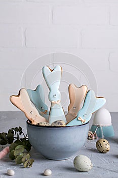 Easter spring decorative composition with homemade easter cookies in the shape of a funny rabbit, quail eggs