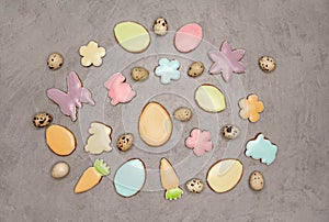 Quail eggs on the grey background. Homemade glazed easter cookies .