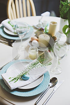 easter and spring scandinavian festive table decorated in blue and white tones in natural rustic style