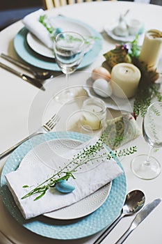 Easter and spring scandinavian festive table decorated in blue and white tones in natural rustic style