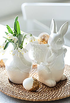 Easter still life with a ceramic hare, eggs and flowers.