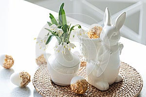 Easter still life with a ceramic hare, eggs and flowers.