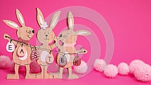 Easter stop motion animation. Beautiful Easter bunnies are moving in the frame holding the inscription Easter on a pink