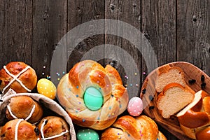 Easter table scene with a selection of fresh breads, above view bottom border over a wood background