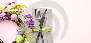 Easter table setting. Egg and flower wreath pastel color and cutlery on pink, overhead