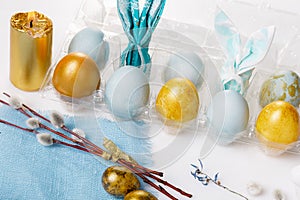 Easter table setting with gold and blue eggs and cutlery. Holidays background.