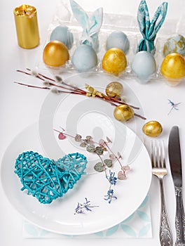 Easter table setting with gold and blue eggs and cutlery. Holidays background.