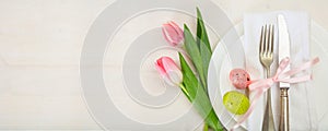 Easter table setting with pink tulips on white wooden background. Top view, copy space, banner