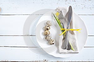 Easter table setting with spring flowers, eggs and cutlery