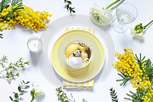 Easter table settings with painted eggs and spring flowers.