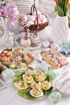 Easter table with stuffed eggs  rolled ham and salad