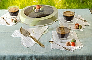 Easter table with tea matcha cheesecake and black coffee on background of green grass