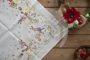 Easter tablecloth with a decorative wreath and a basket with a red egg