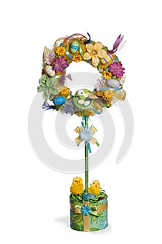 The Easter topiary with yellowe chicks, eggs, nest, feathers over white background