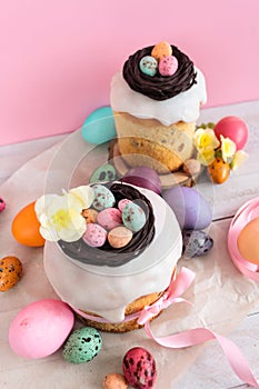 Easter traditional cake with chocolate nest, candy and quail eggs decoration blossom flowers, colorful spring stillife in soft lig