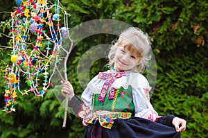 Easter traditional folk costume complimenting on Easter with colorful eggs hang on green branch