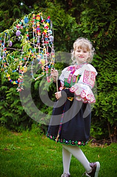 Easter traditional folk costume complimenting on Easter with colorful eggs hang on green branch