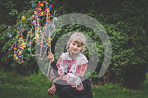 Easter traditional folk costume complimenting on Easter with colorful eggs hang on green branch