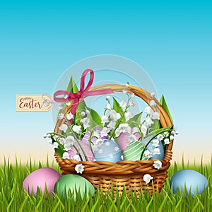 Easter wicker basket with flowers in grass photo