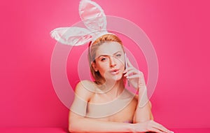Easter woman with rabbit ears talking on phone.