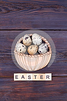 Easter word and quail eggs basket.