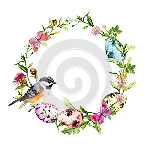 Easter wreath with colored eggs, bird in grass, flowers. Round frame. Watercolor