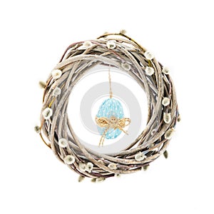 Easter wreath decorated with pussy willow branches and blue Easter egg on white background. Easter celebration concept. Copy space