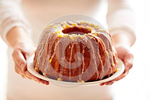 Easter Yeast cake on a white plate held by female hands, when served to the table.