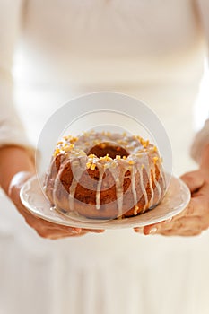 Easter Yeast cake on a white plate held by female hands, when served to the table. ,